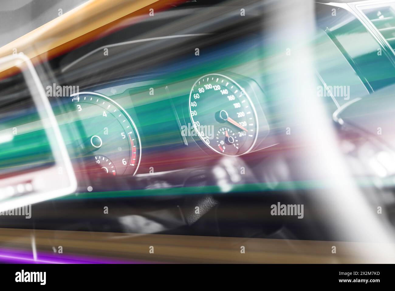 Speedometer and tachometer behind steering wheel in car, motion blur ...