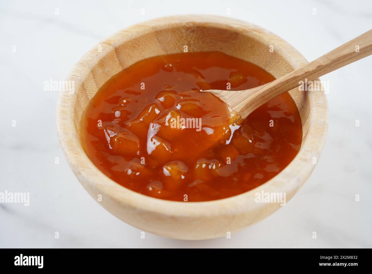 Peach jam in a wooden bowl.  Canned fruit jam with ingredients Stock Photo