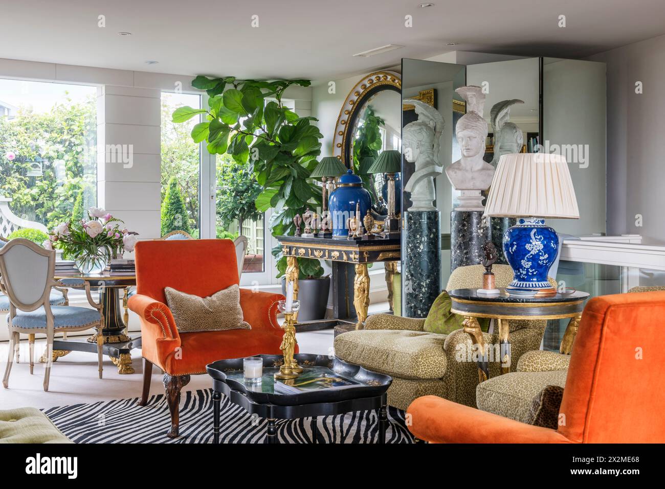 Lamp on table with matching velvet armchairs in Chelsea apartment, London UK Stock Photo