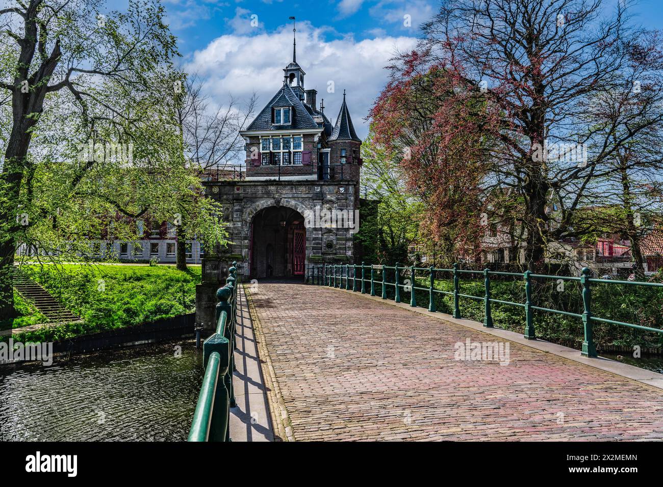 View of the renaissance architecture Oosterpoort gate from the golden age and adjoining bridge in the Dutch city of Hoorn, blue clouds sky in spring Stock Photo