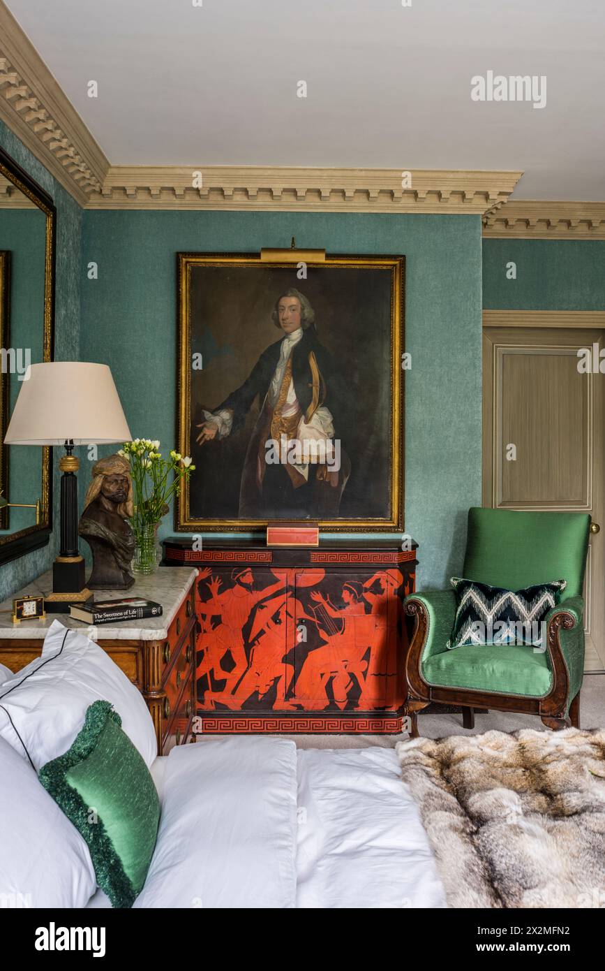 Framed portrait above console with chair in Chelsea apartment, London UK Stock Photo