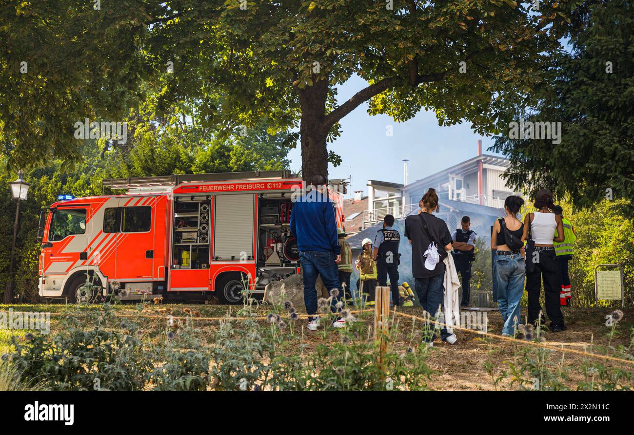 Trotz starker Rauchentwicklung wegen eines Containerbrandes, schauen zahlreiche Personen der Feuerwehr Freiburg im Breisgau bei den Löscharbeiten zu. Stock Photo