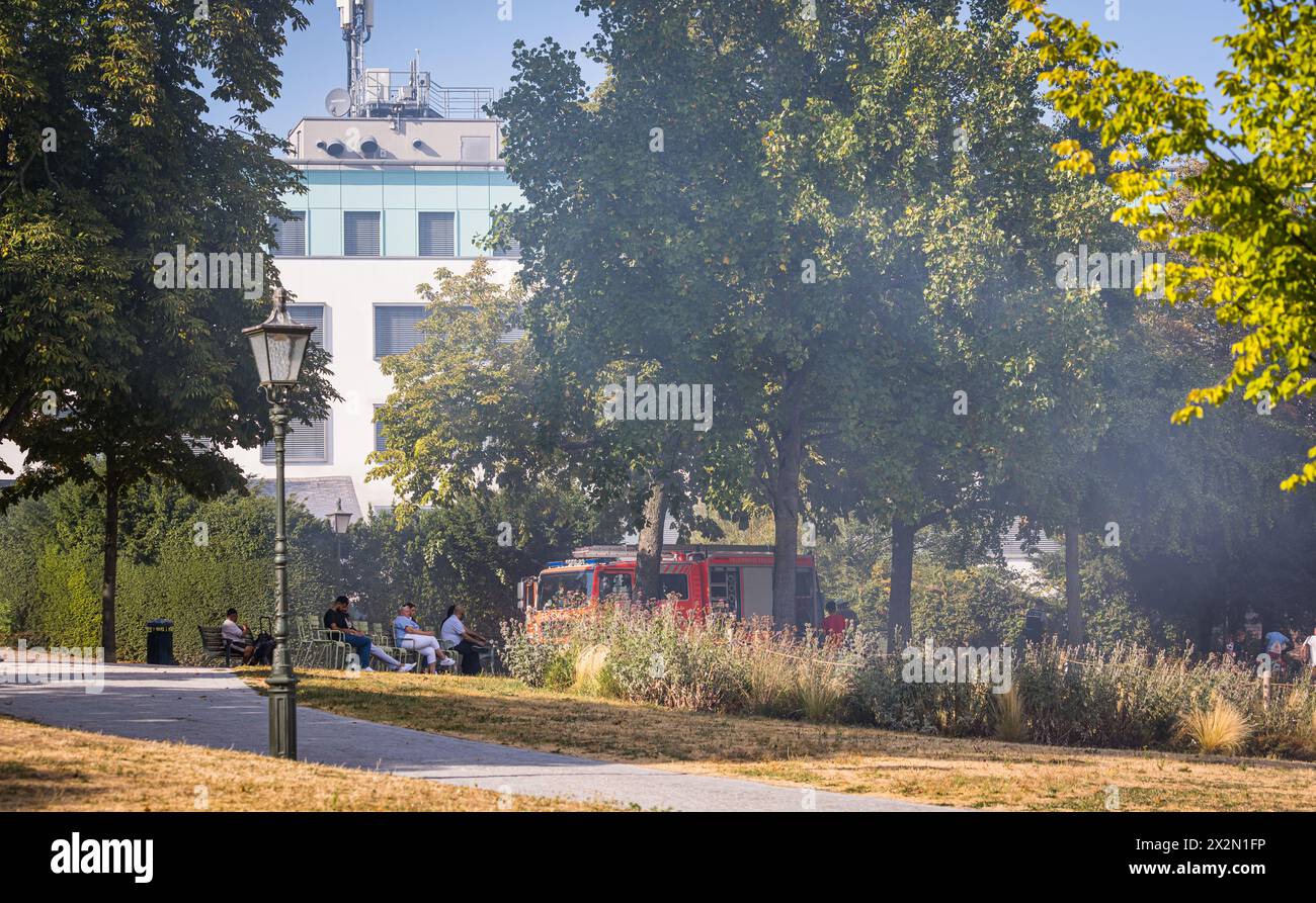 Trotz starker Rauchentwicklung wegen eines Containerbrandes, schauen zahlreiche Personen der Feuerwehr Freiburg im Breisgau bei den Löscharbeiten zu. Stock Photo