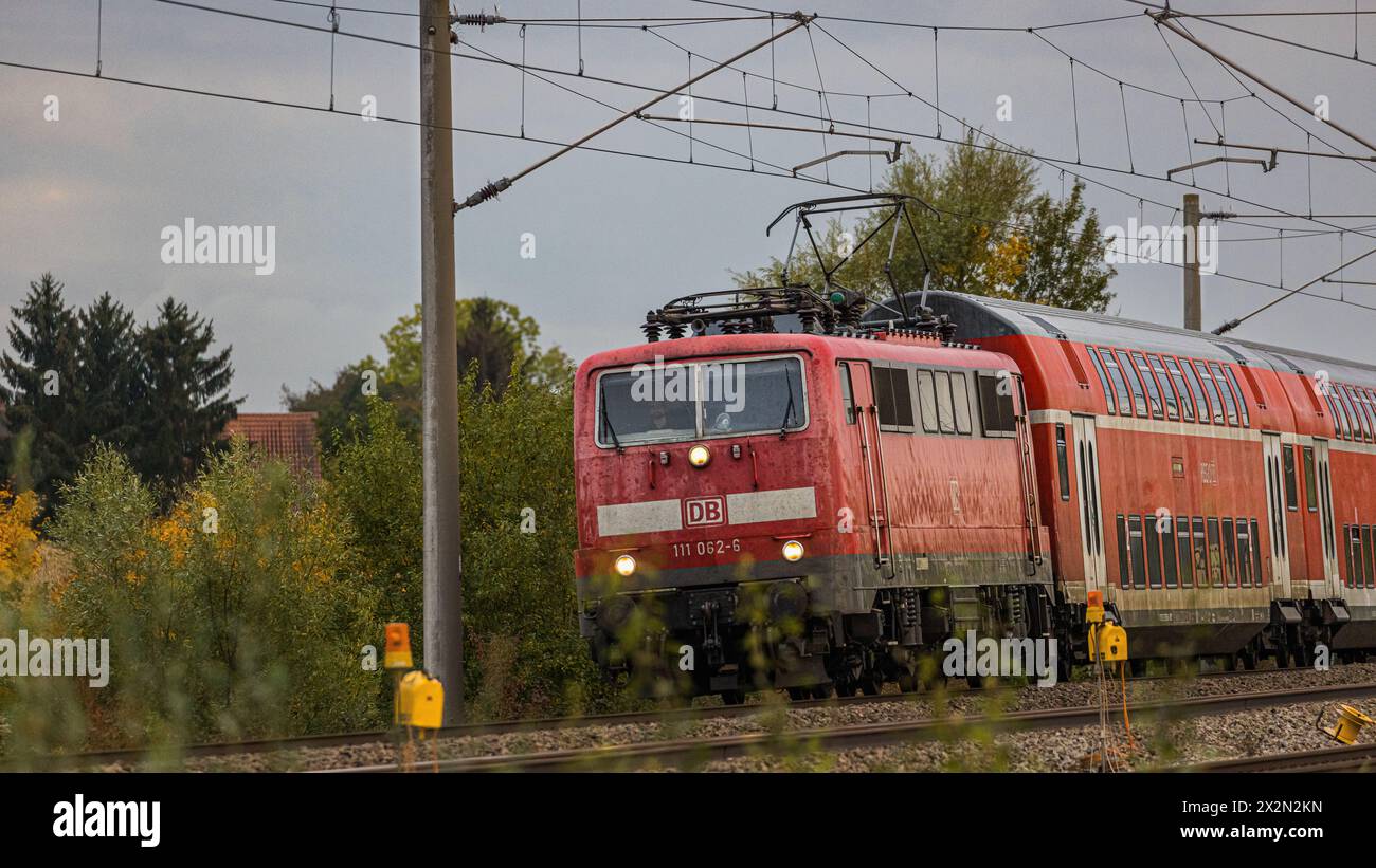 Ein Personenzug mit einer Lokomotive der Baureihe 111 der Deutschen Bahn ist mit Doppelstockwagen auf der Bahnstrecke zwischen Nürnberg und München un Stock Photo