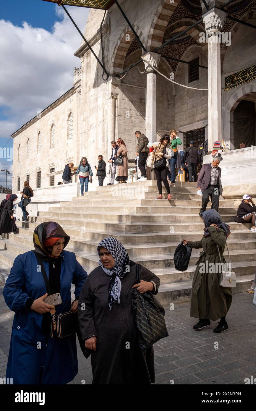 A veiled woman leaving prayer at the New Mosque (Yeni Cami or Valide Sultan Camii), an imperial Ottoman mosque, in Istanbul, Turkey's largest city on Stock Photo