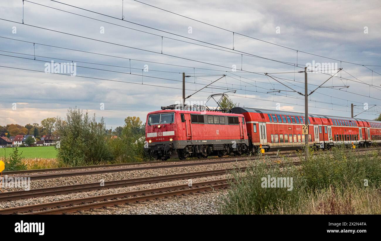 Ein Personenzug mit einer Lokomotive der Baureihe 111 der Deutschen Bahn ist mit Doppelstockwagen auf der Bahnstrecke zwischen Nürnberg und München un Stock Photo