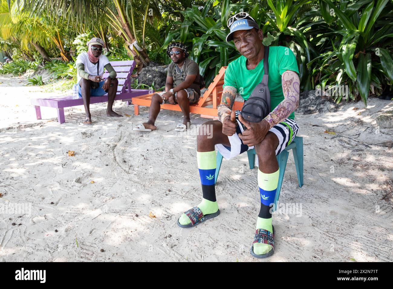 Beech worker relaxing while smoking on Seven Mile Beech, Negril, Jamaica. June 2023. Stock Photo