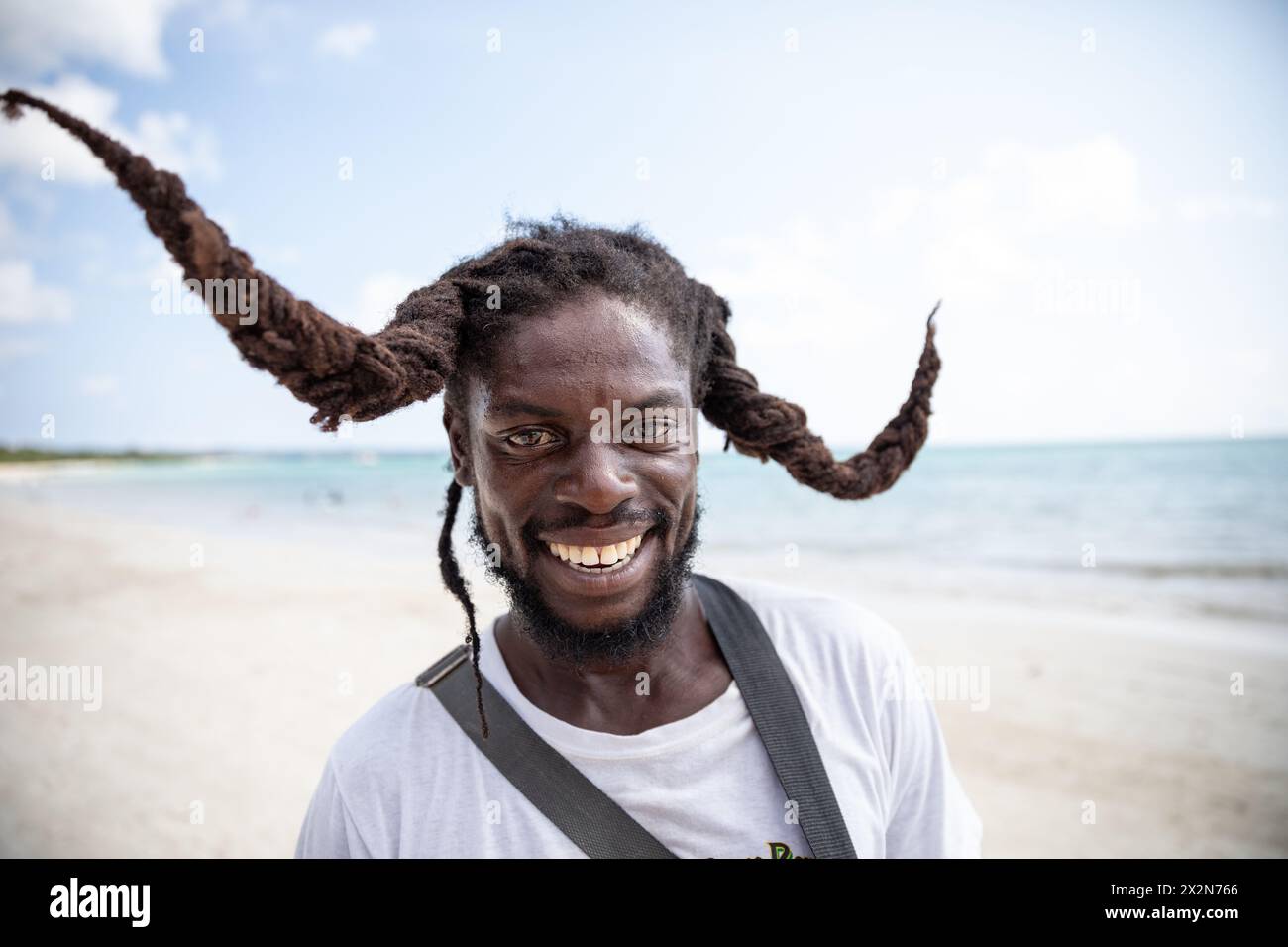 Beechworker 'Jason' smiles for a portrait on Negril's 7 mile beech, Jamaica a scenic spot for swimming and snorkelling. June 2023. Stock Photo