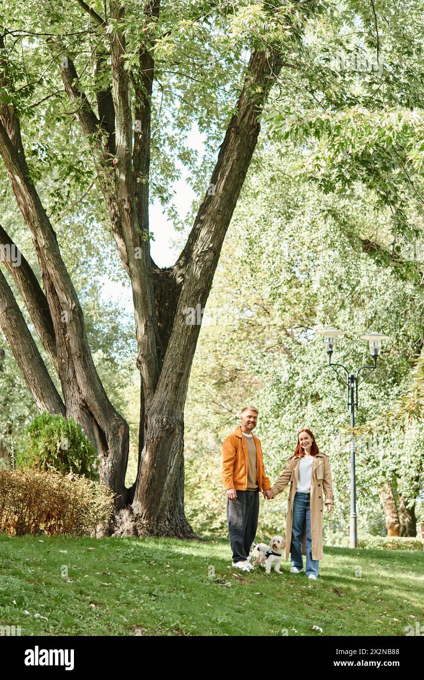 Adult couple enjoying a walk with their dog in the park Stock Photo - Alamy