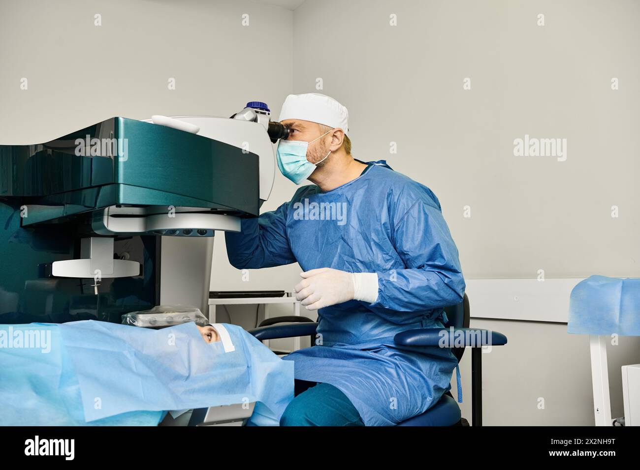 A man in surgical gown operates a medical machine. Stock Photo