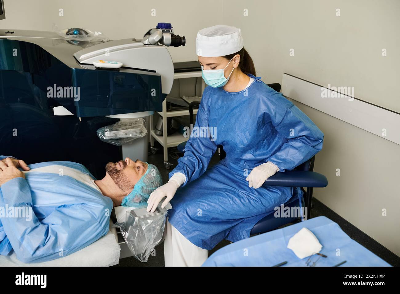 Woman and man in blue gowns await laser vision correction at hospital. Stock Photo