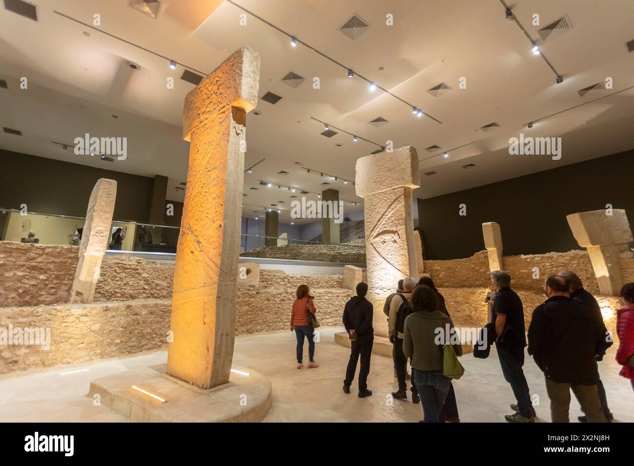 Replicas of neolithic T-shaped stone pillars found in Gobeklitepe and visitors, Sanliurfa Museum, Sanliurfa, Turkey Stock Photo