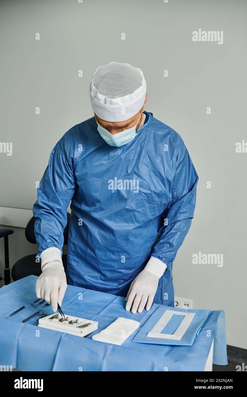 A man in surgical gown meticulously preparing his tools. Stock Photo