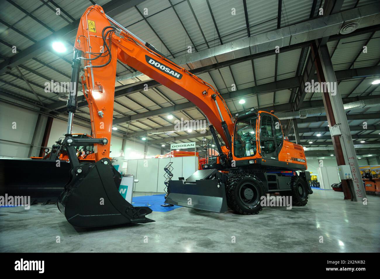 New model of the backhoe Doosan parked on a stand. Exhibition Heavy ...