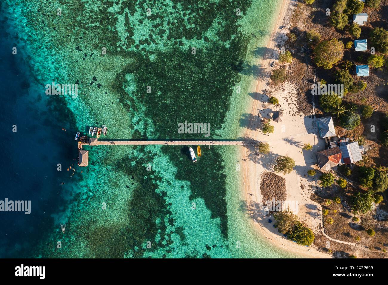 Komodo, Indonesia: Top down view of the Kanawa island with beach bungalows, the jetty and reef in Komodo islands near Labuan Bajo in Flores, Indonesia Stock Photo