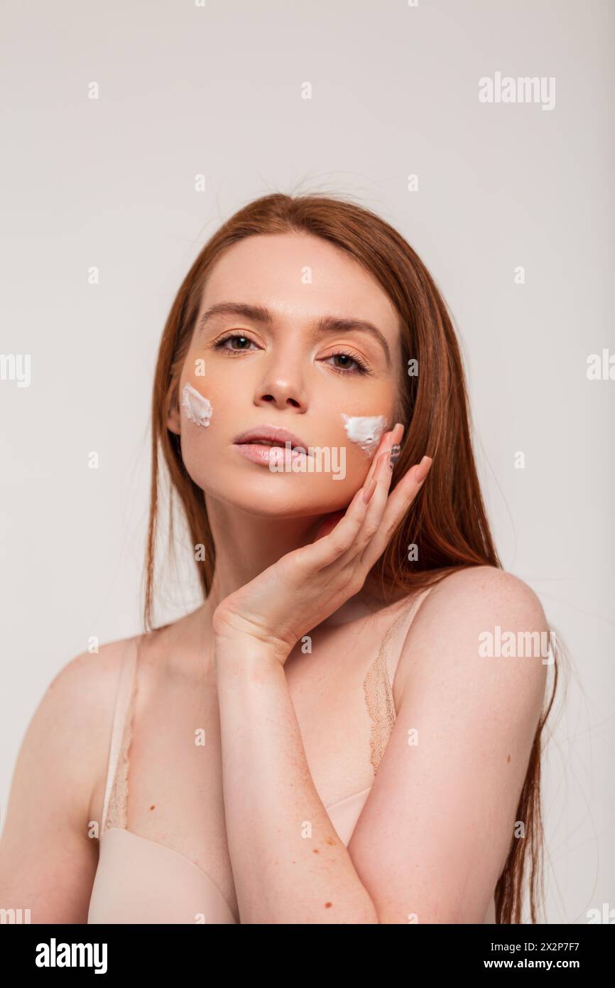 Beautiful Natural Redhead Woman Moisturizes Her Face And Applies Cream. Beauty And Skin Care Stock Photo