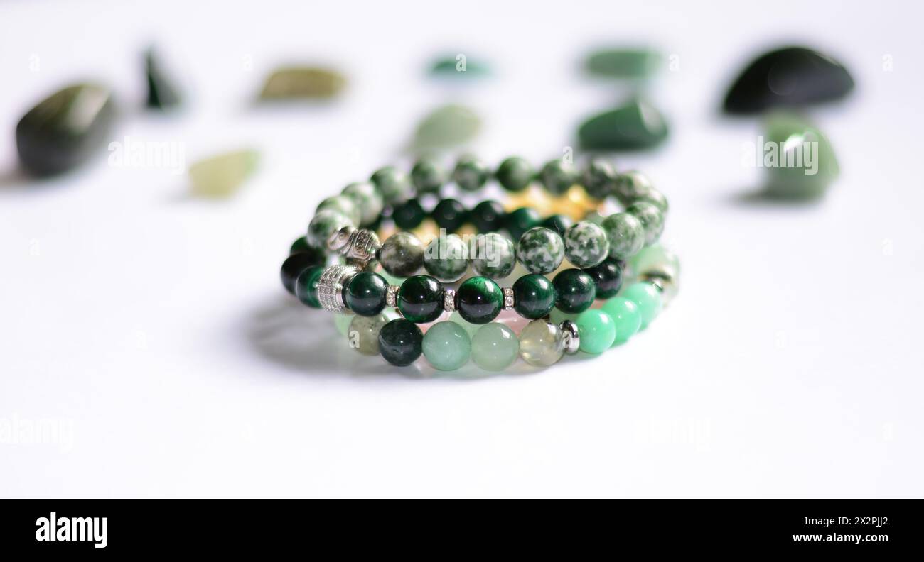 a collection of various green raw mineral gemstones and handmade bracelets Stock Photo