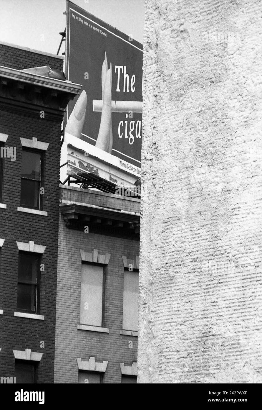 Connecticut, U.S.A., 1982. Old brick buildings in the city with a large billboard on a roof  promoting a cigarette brand. Stock Photo