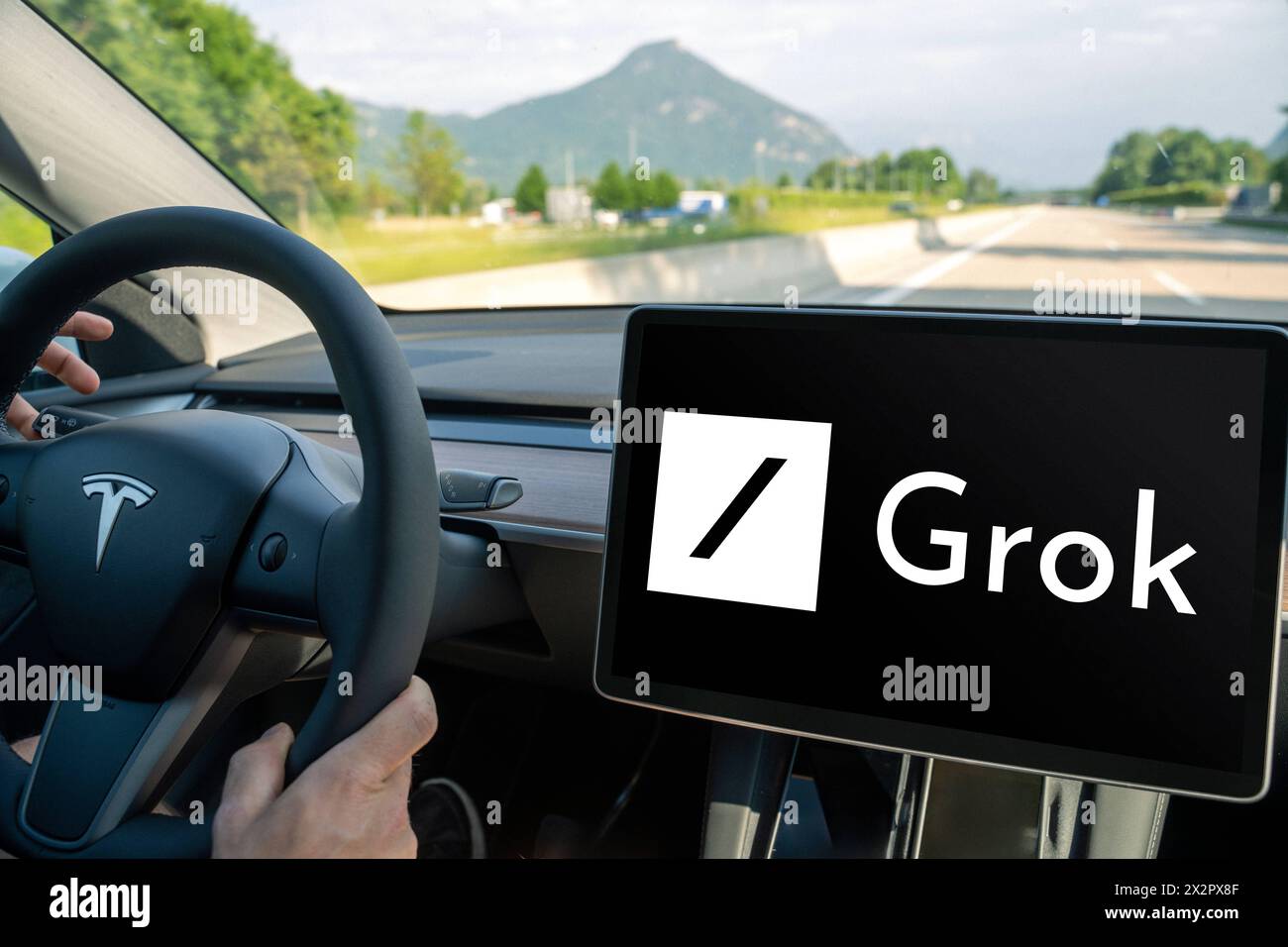 April 23, 2024: Man drives a Tesla car with the X Ai Groko logo on the screen. PHOTOMONTAGE *** Mann fährt ein Tesla Auto mit dem Logo der X Ki Groko auf dem Bildschirm. FOTOMONTAGE Stock Photo