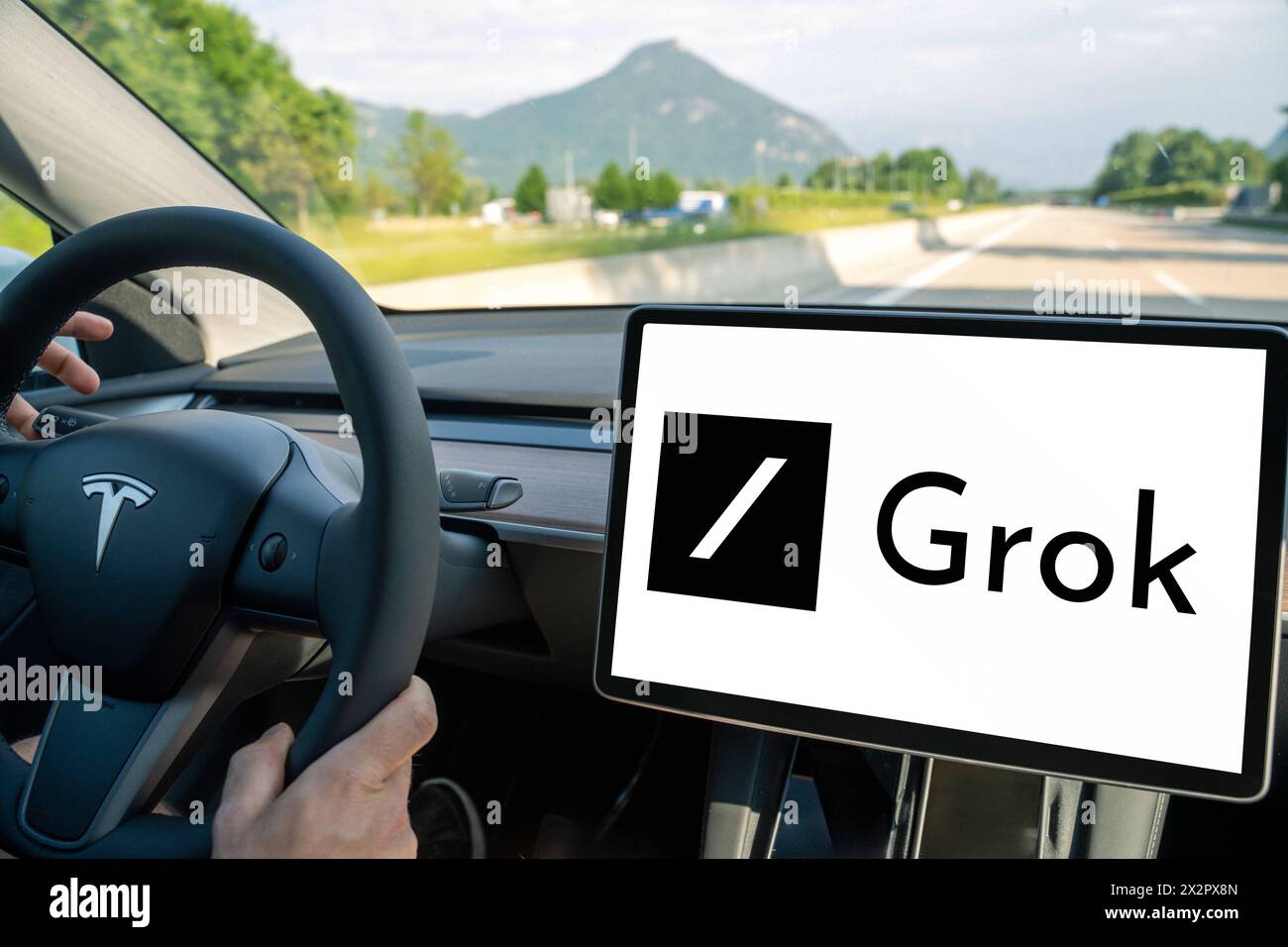 April 23, 2024: Man drives a Tesla car with the X Ai Groko logo on the screen. PHOTOMONTAGE *** Mann fährt ein Tesla Auto mit dem Logo der X Ki Groko auf dem Bildschirm. FOTOMONTAGE Stock Photo