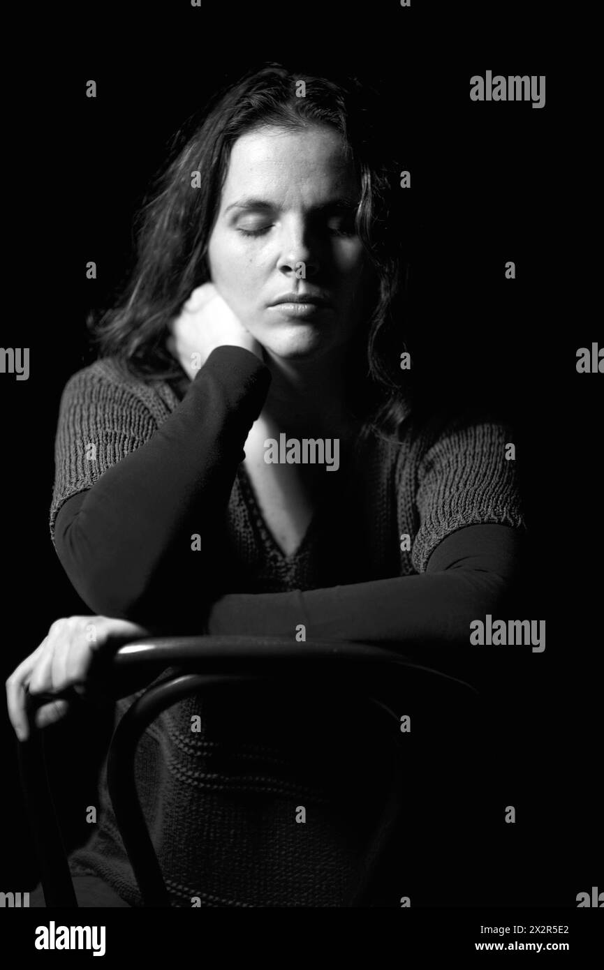 One woman sitting chair eyes closed Black and White Stock Photos ...
