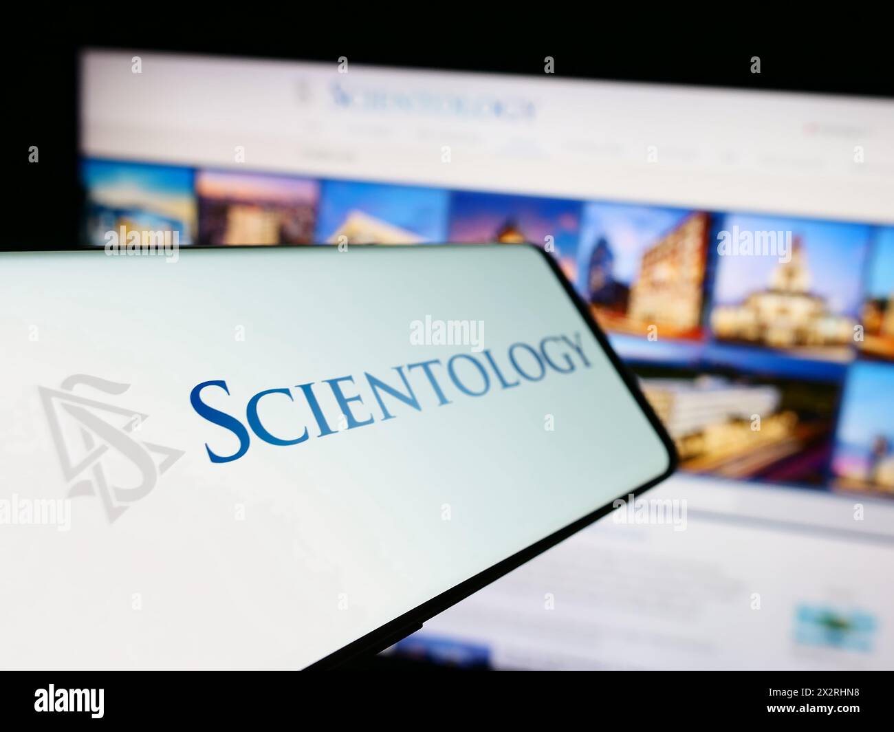 Smartphone with logo of religious organisation Scientology in front of