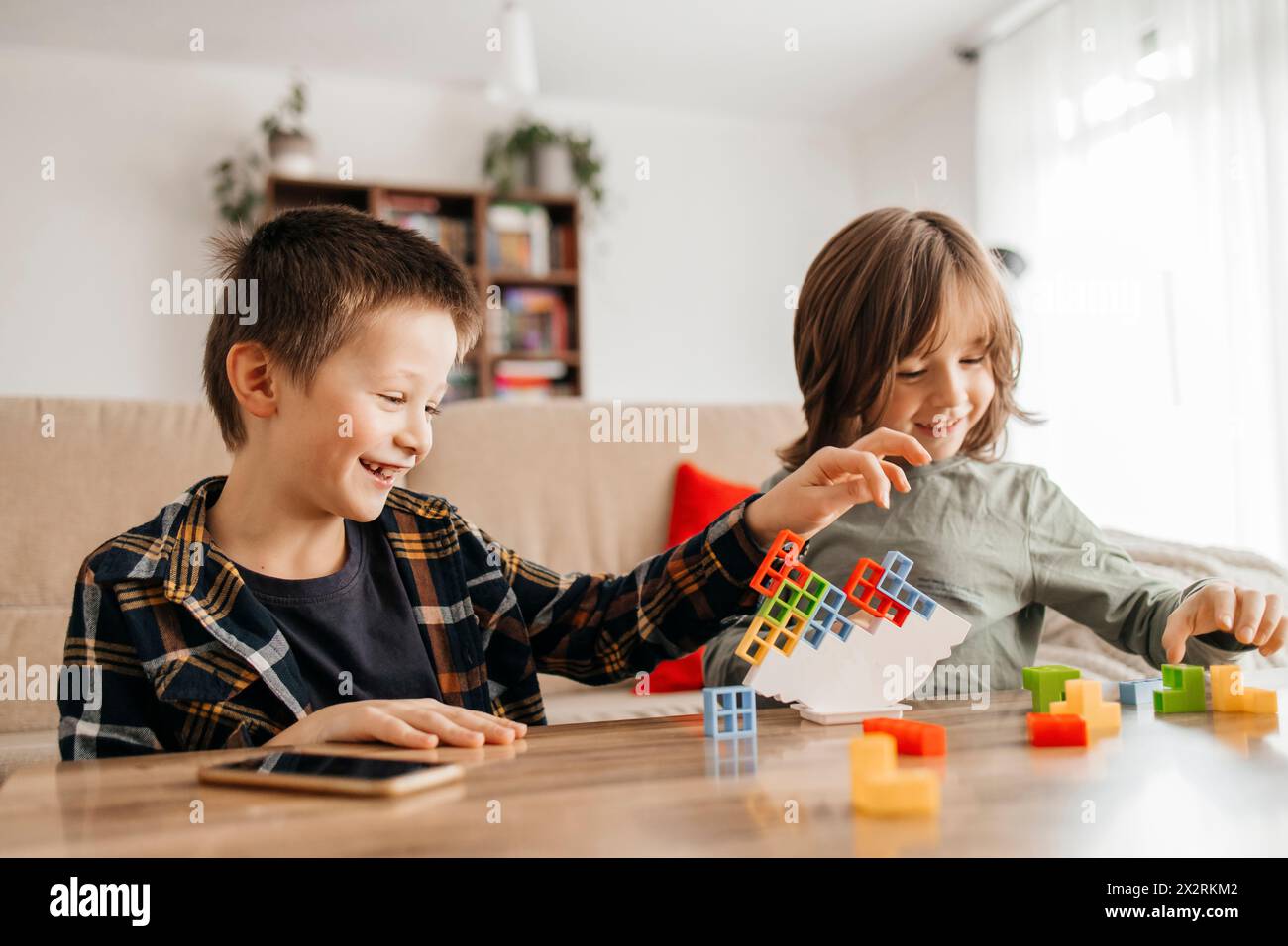 Happy boys playing balance game at home Stock Photo