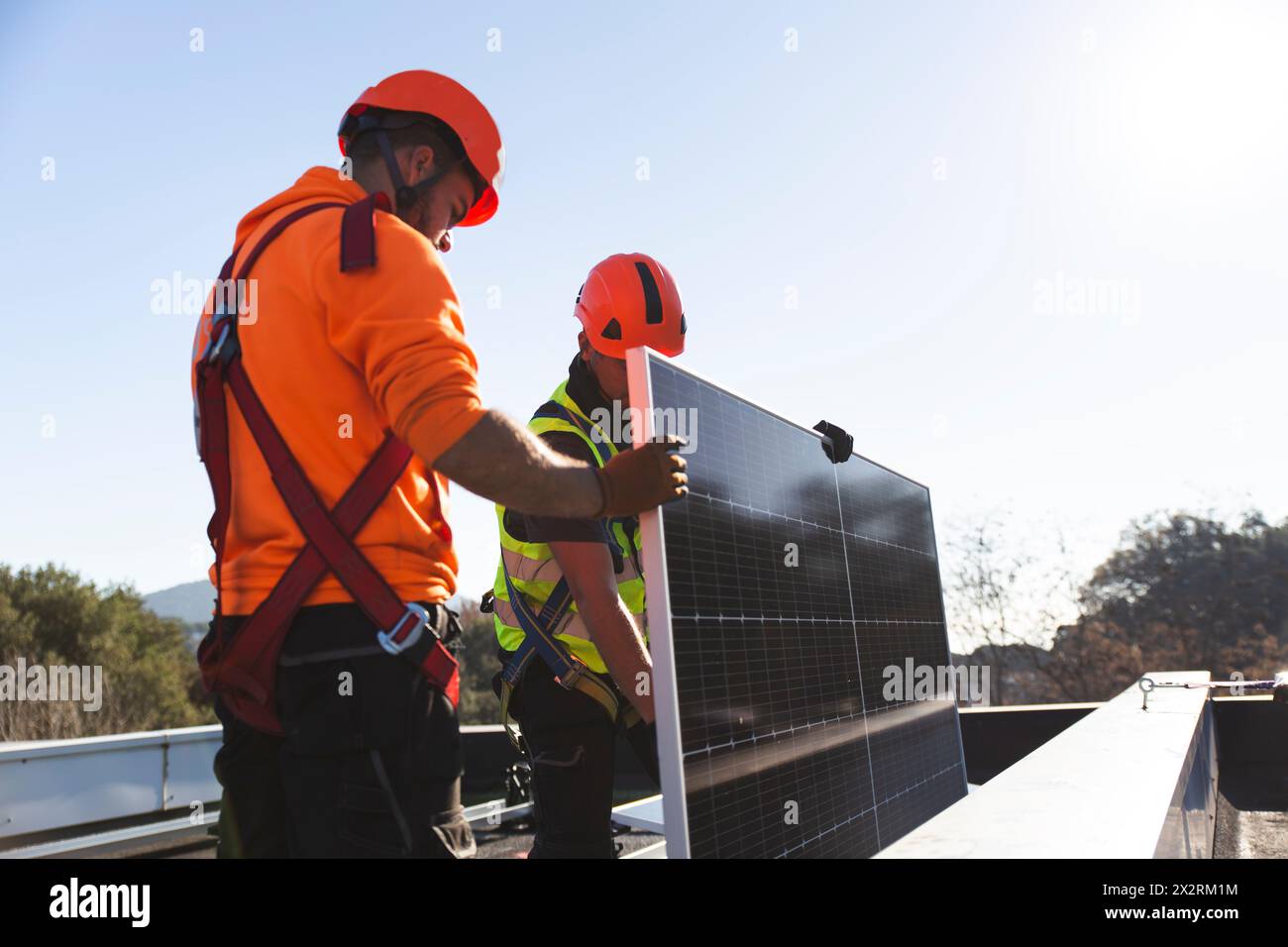 Two engineers installing solar equipment on rooftop3 Stock Photo
