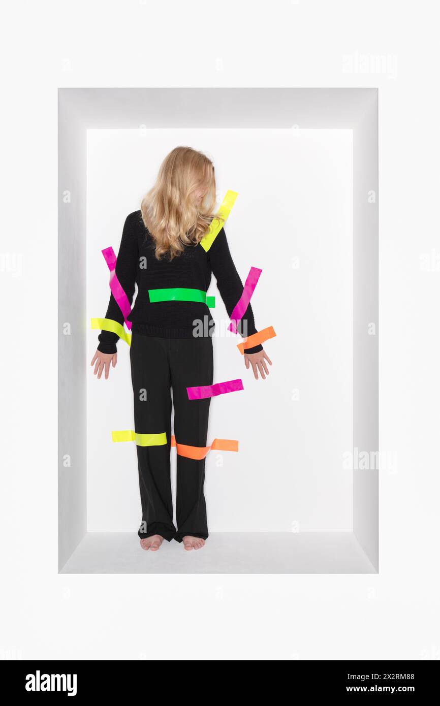 Blond teenage girl with colorful adhesive tapes stucked on body Stock