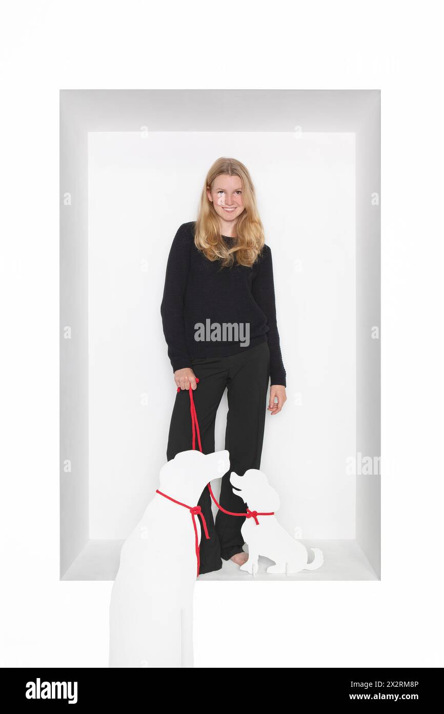 Smiling teenage girl with dog cut out standing against white background Stock Photo