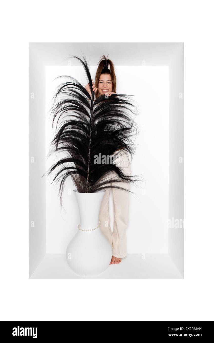 Teenage girl with vase and feather in alcove Stock Photo