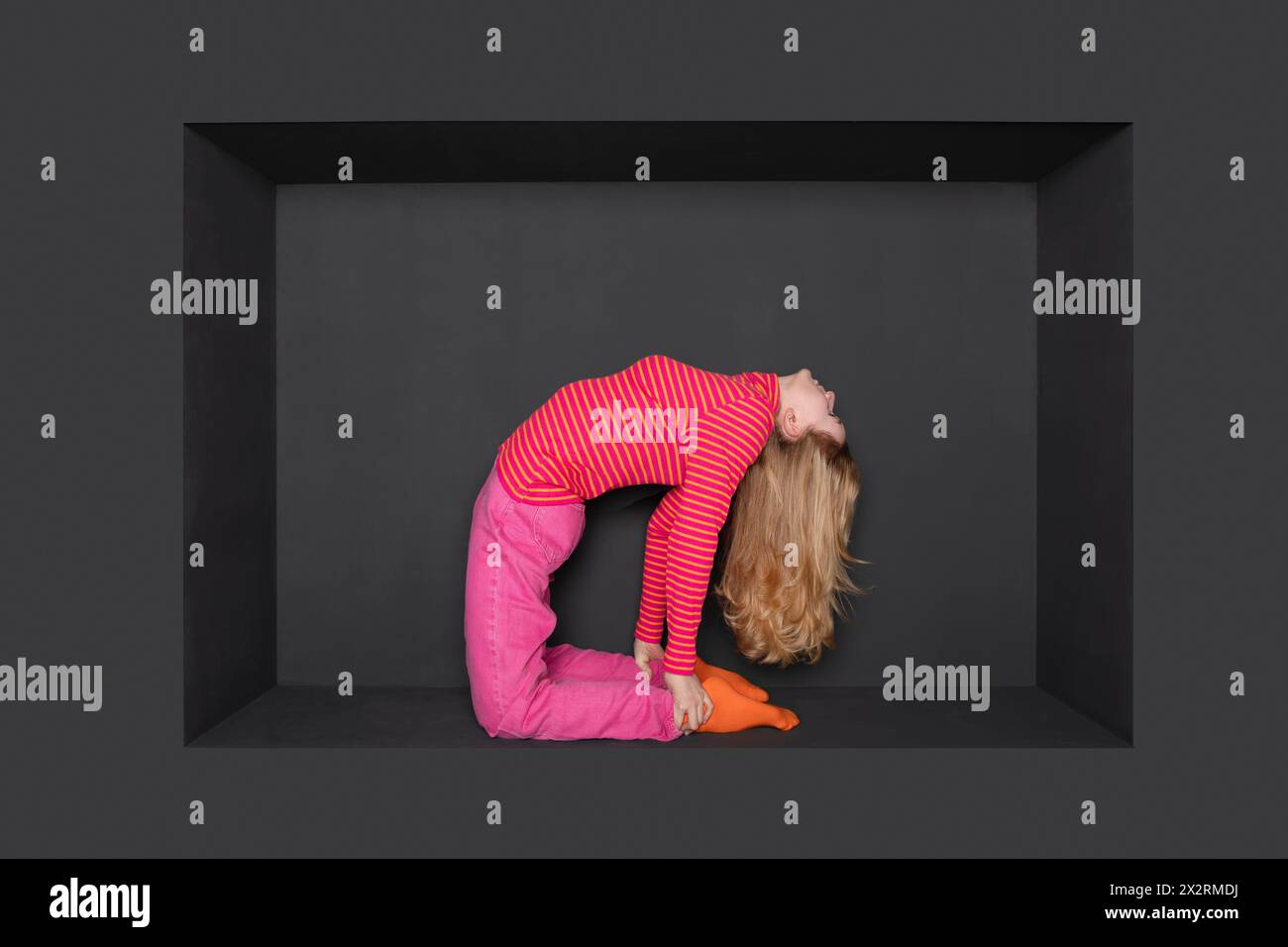 Blond teenage girl bending backward in alcove over black backward Stock Photo