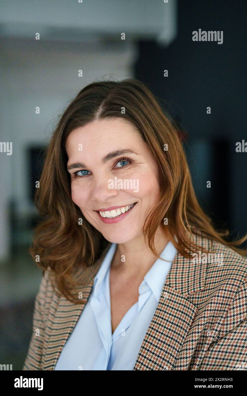 Confident mature businesswoman in blazer at office Stock Photo