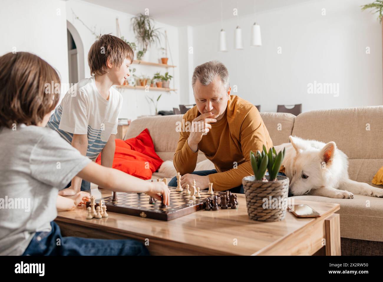 Father and son playing chess on table at home Stock Photo