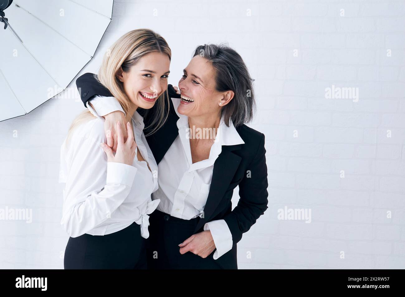 Happy mother and daughter having fun in front of wall Stock Photo
