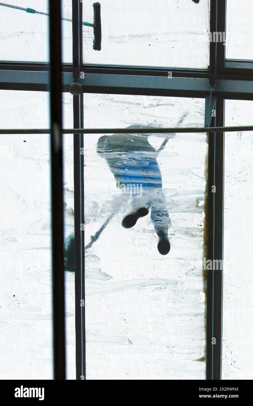 Directly below view of window washer on glass ceiling Stock Photo