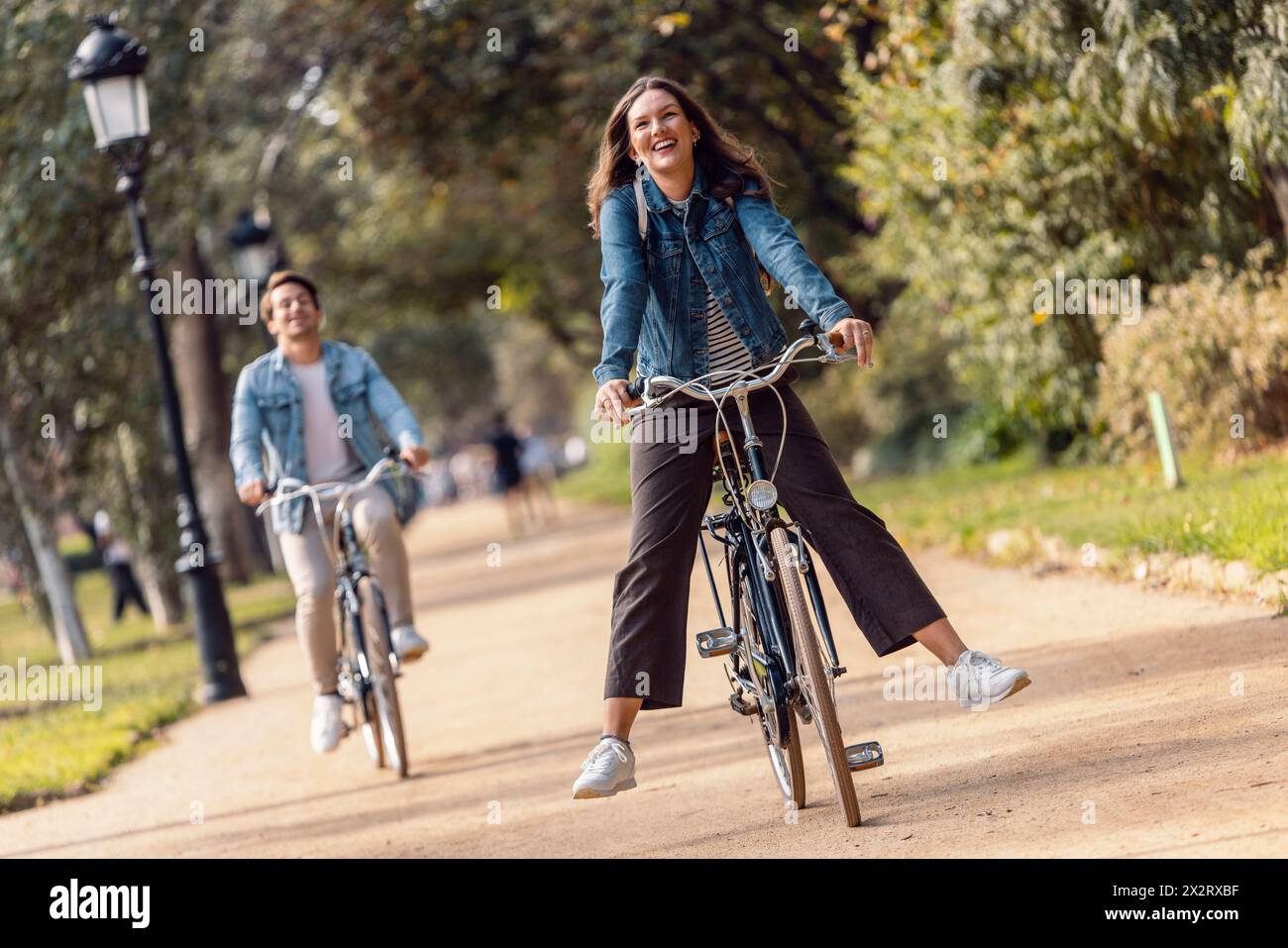 Carefree woman cycling with boyfriend at park Stock Photo