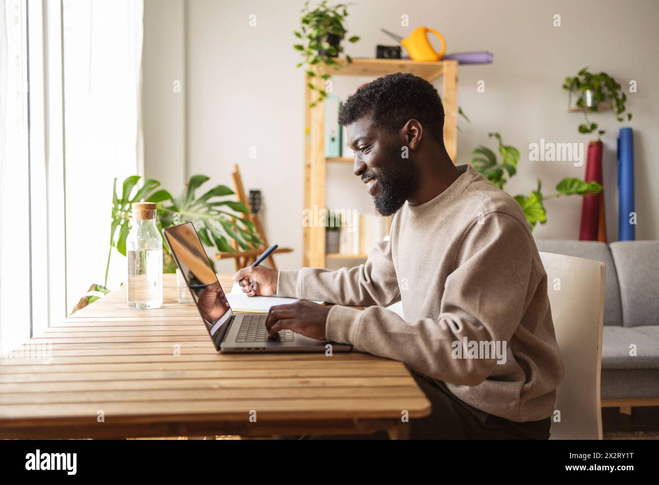 Smiling freelancer working on laptop at home Stock Photo