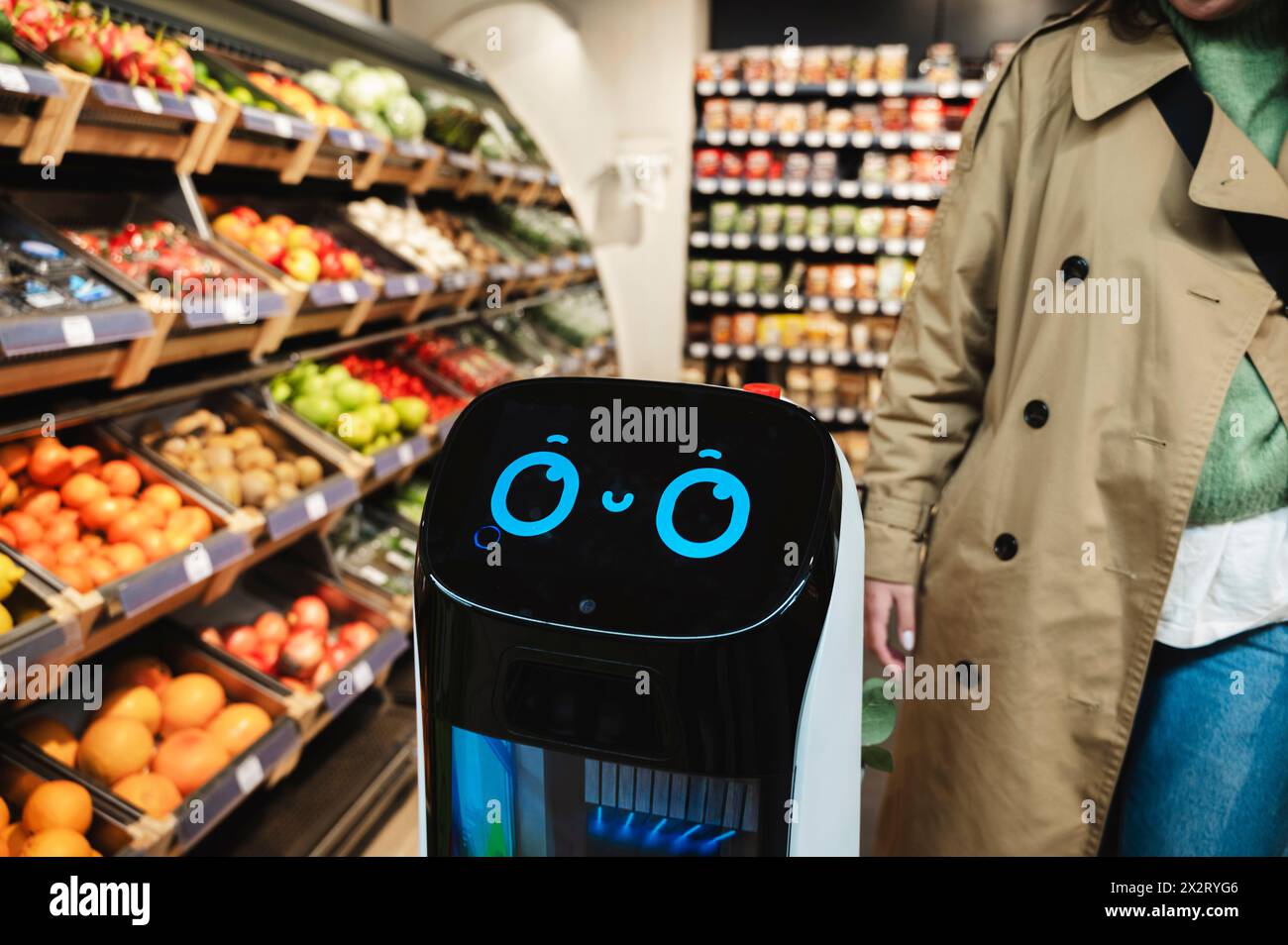 Smart robot assistant near woman at grocery store Stock Photo
