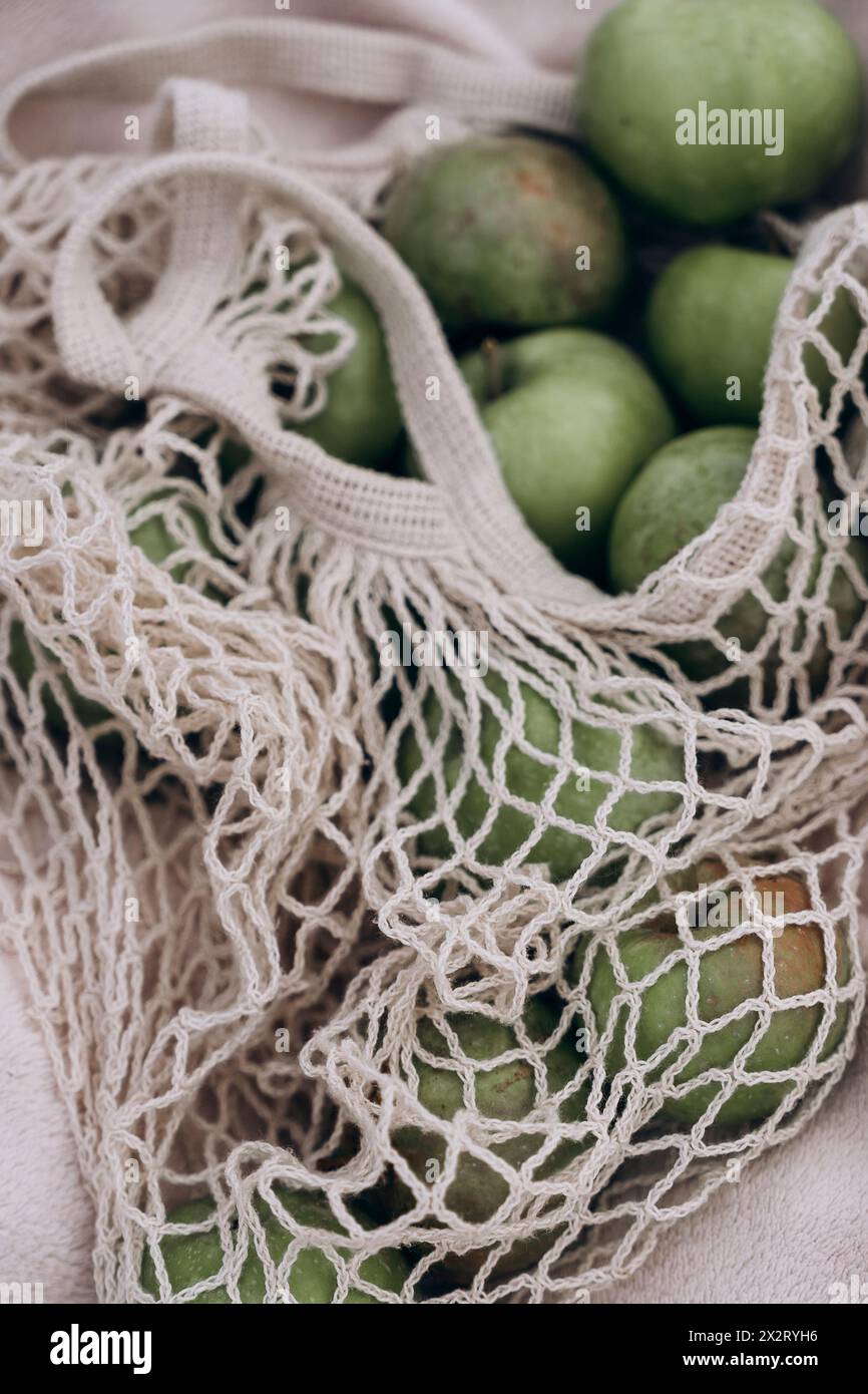 Green apples in white mesh bag Stock Photo