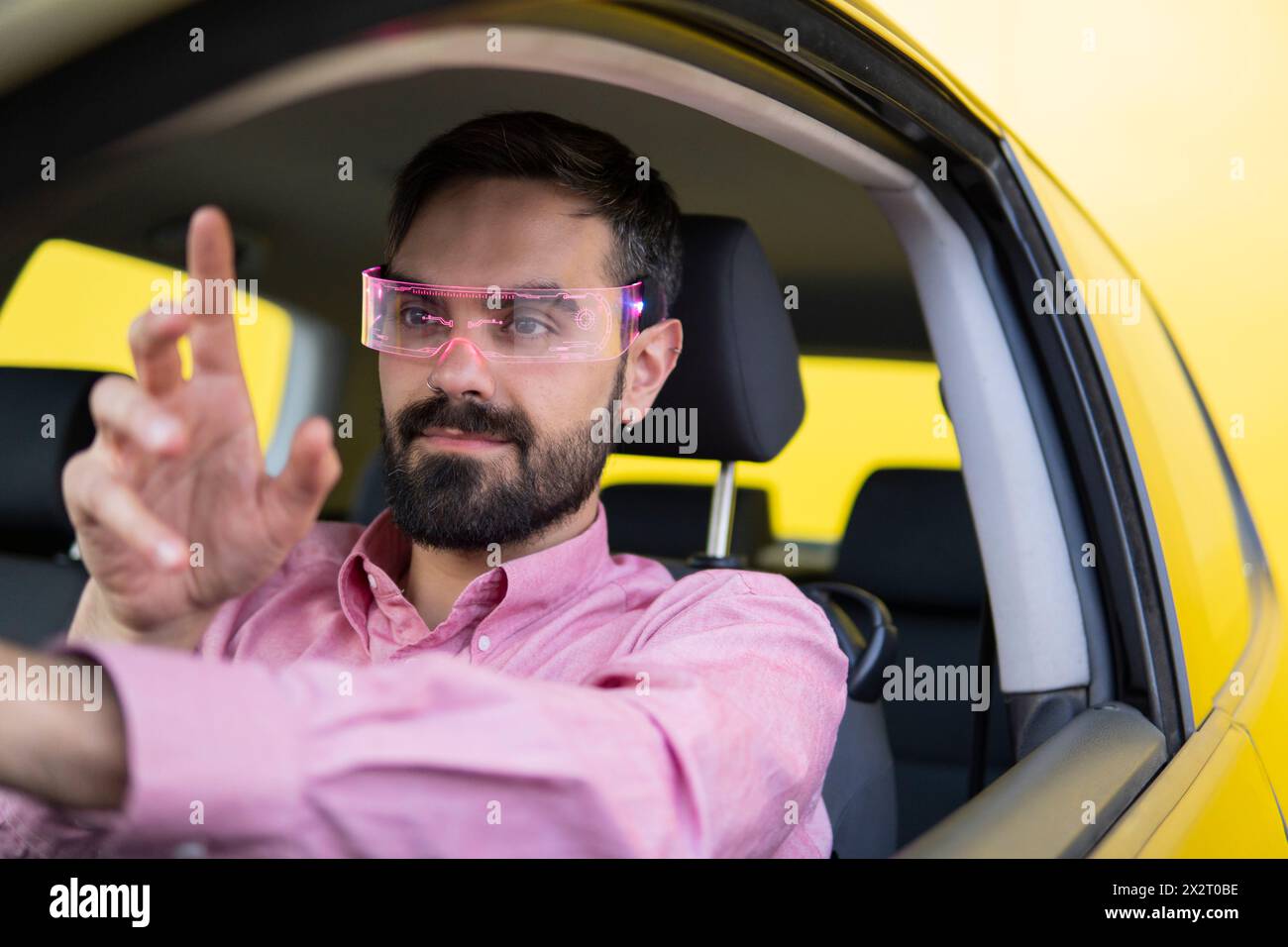 Man wearing smart glasses and gesturing in car Stock Photo