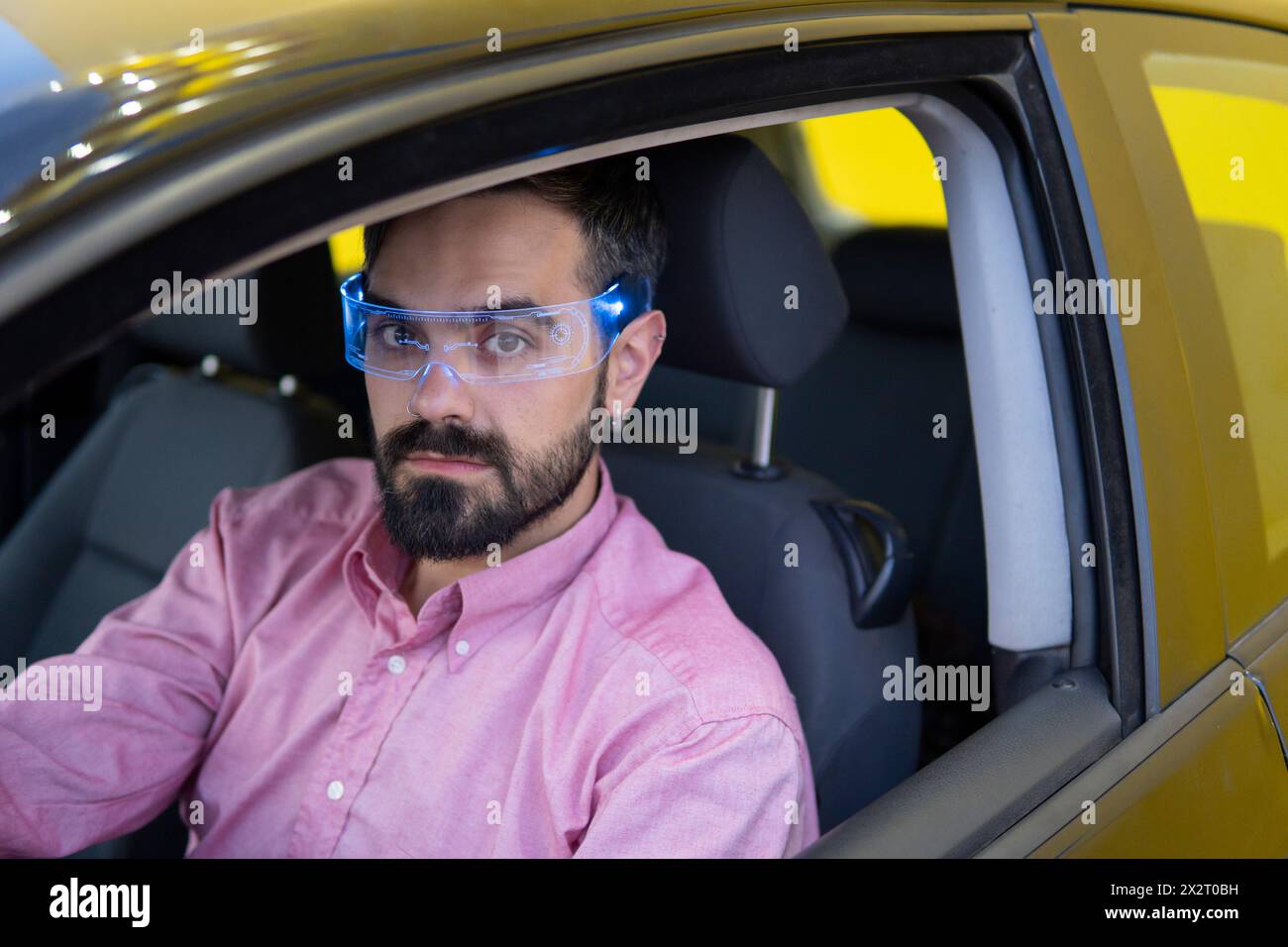 Man wearing smart glasses and sitting inside car Stock Photo