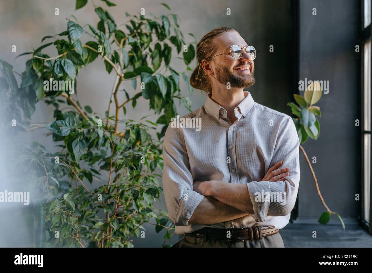 Happy businessman standing with arms crossed in office Stock Photo - Alamy