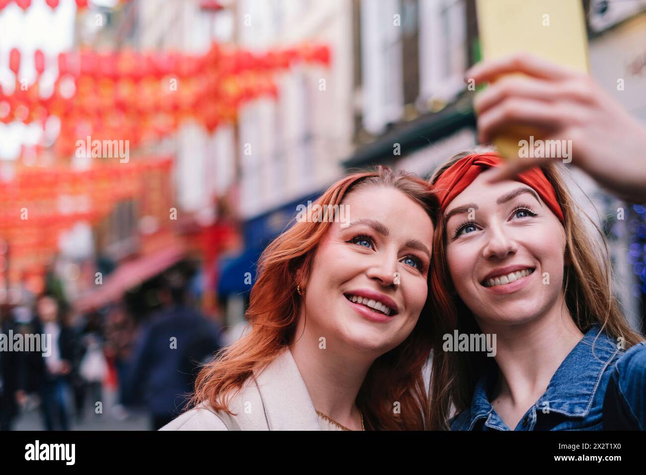 Smiling friends taking selfie through smart phone Stock Photo