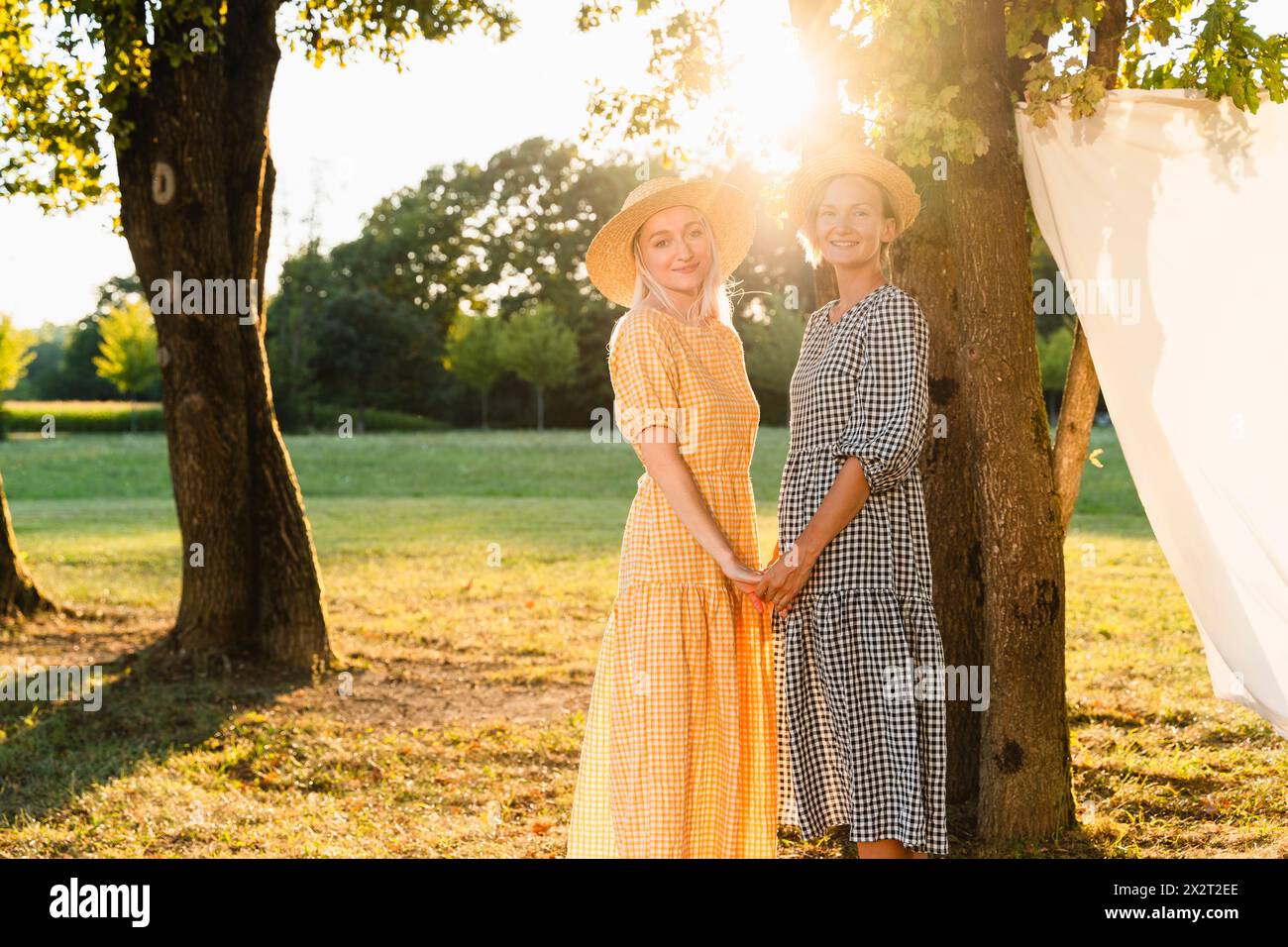 Friends holding hands standing in park Stock Photo