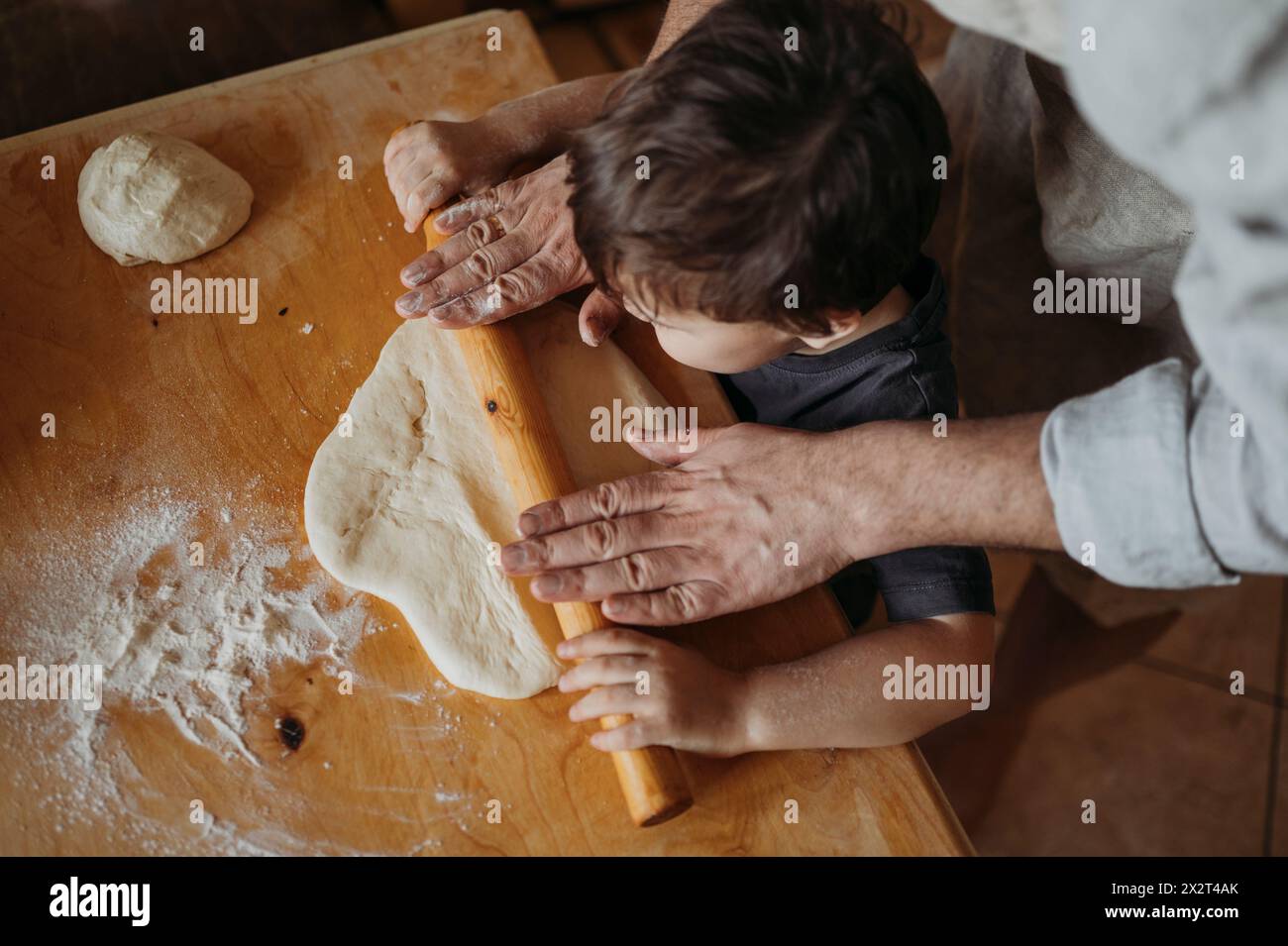 Son helping father in kitchen at home Stock Photo