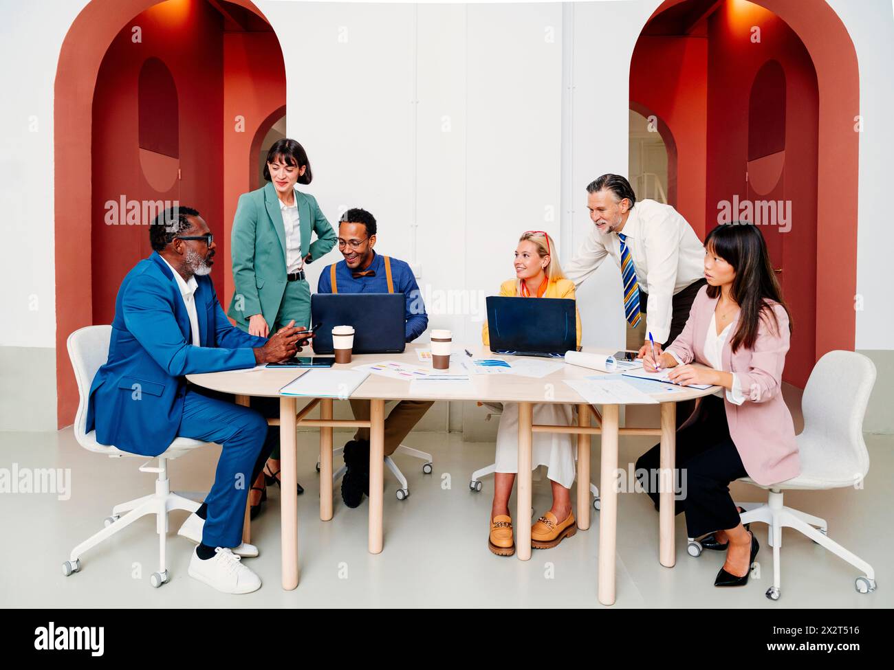 Corporate business colleagues working together at desk in office Stock Photo