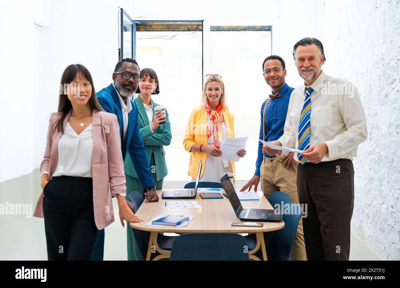 Smiling multi-ethnic business colleagues standing by desk at office Stock Photo