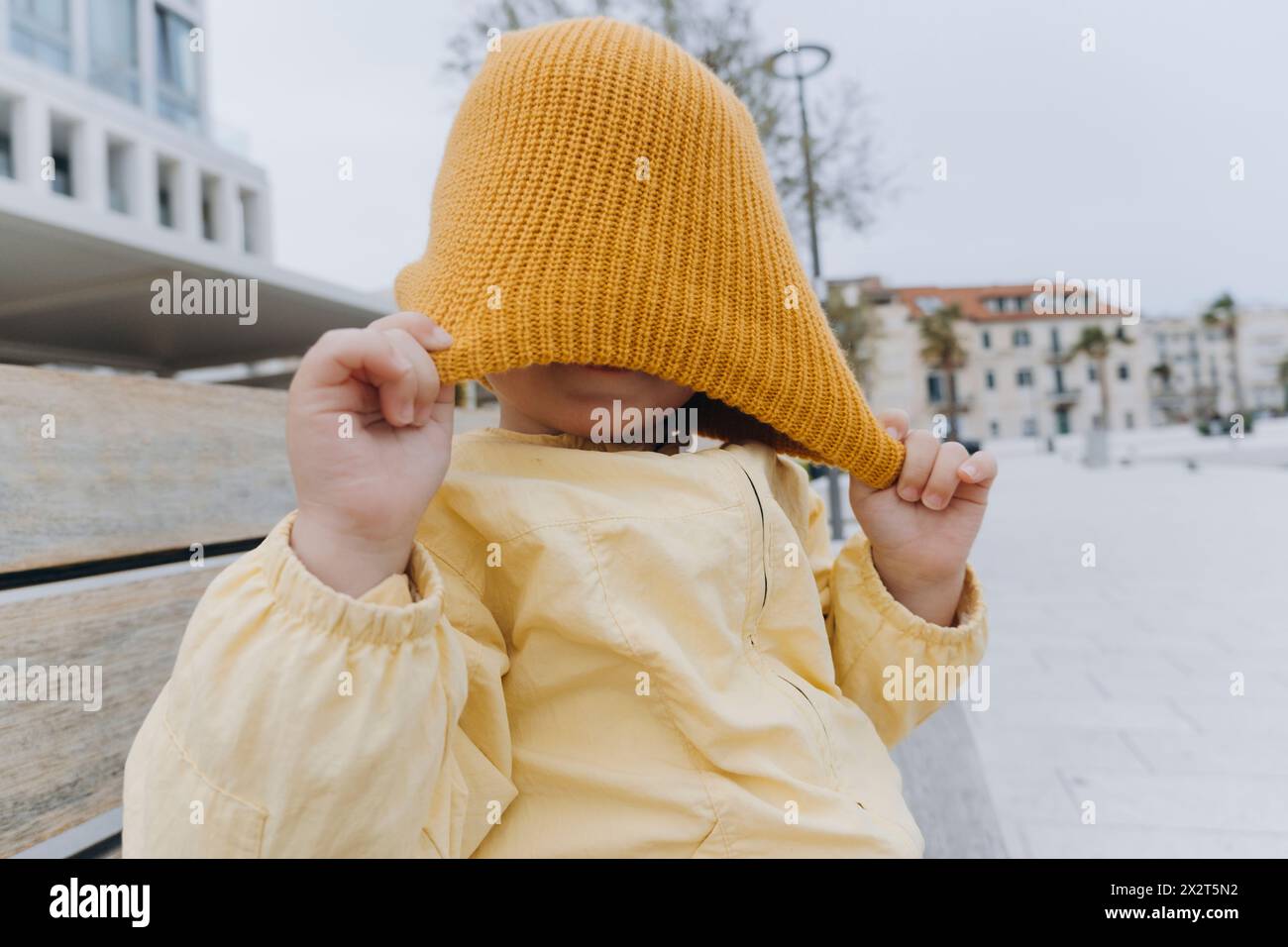 Boy playing with orange knit hat Stock Photo