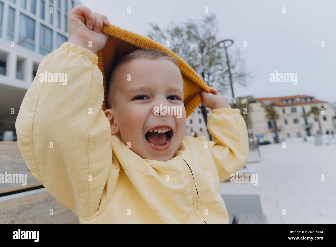 Cute boy playing with orange knit hat Stock Photo